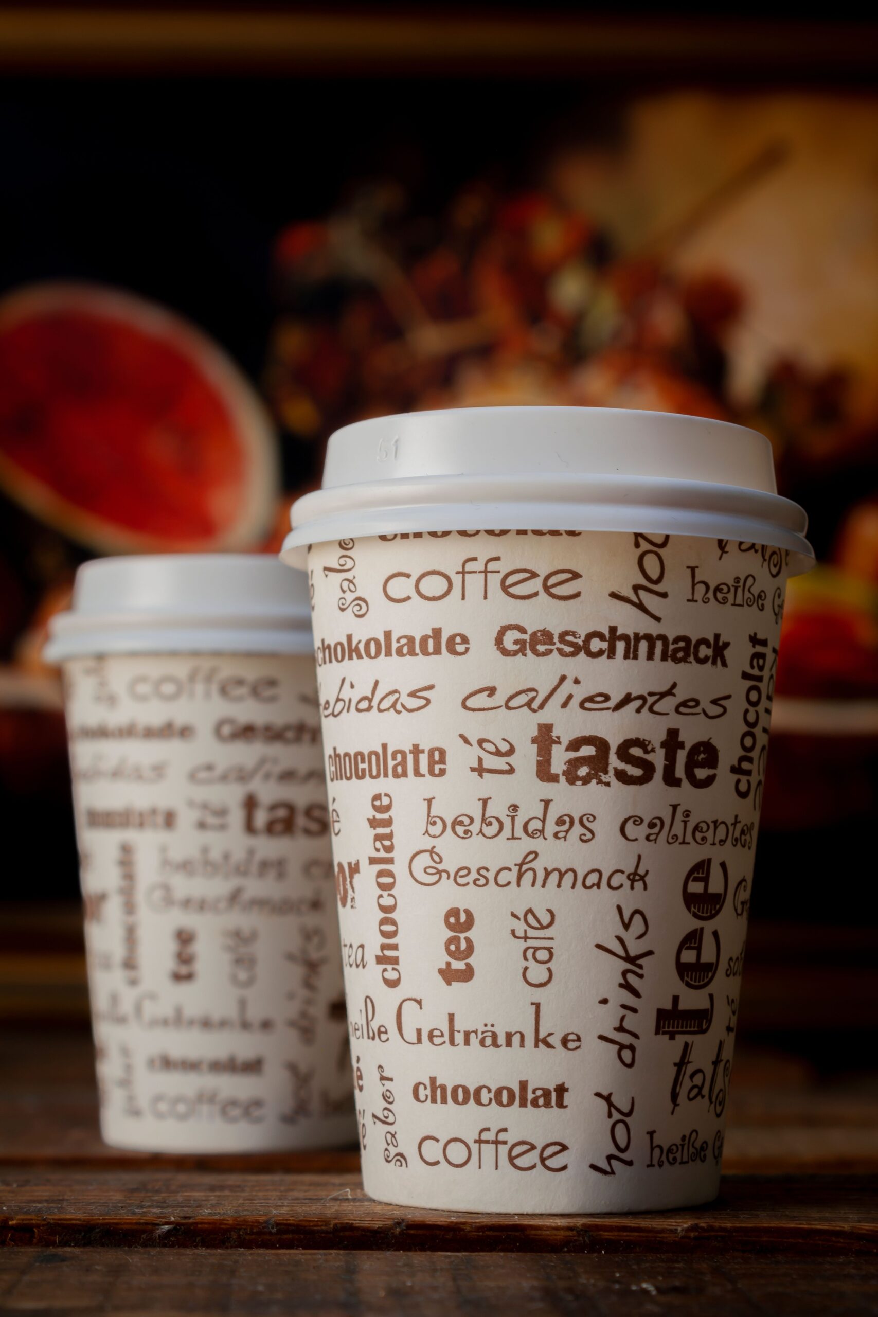 Artistic shot of takeout coffee cups with multilingual text, emphasizing taste.